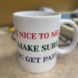 White mug with red, green, and navy writing